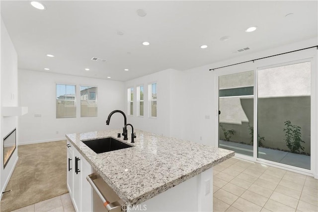 32813 Brunello Way, Temecula, CA 92591 - kitchen with stainless steel dishwasher, white cabinetry, light carpet, recessed lighting, and a kitchen island with sink