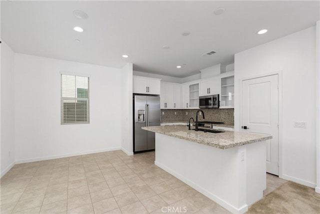 32813 Brunello Way, Temecula, CA 92591 - kitchen with appliances with stainless steel finishes, decorative backsplash, a center island with sink, white cabinets, and light stone counters