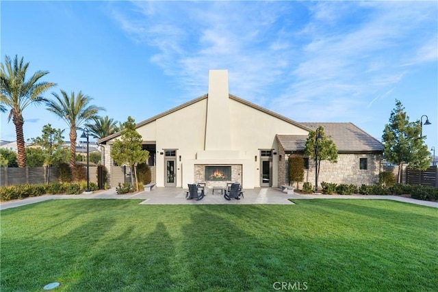 32813 Brunello Way, Temecula, CA 92591 - rear view of property featuring a warm lit fireplace, a patio, stone siding, and stucco siding