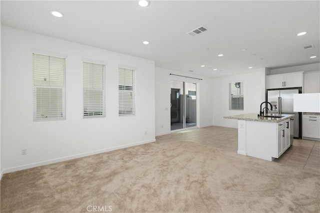 32813 Brunello Way, Temecula, CA 92591 - kitchen featuring light carpet, recessed lighting, a center island with sink, stainless steel refrigerator with ice dispenser, and white cabinets