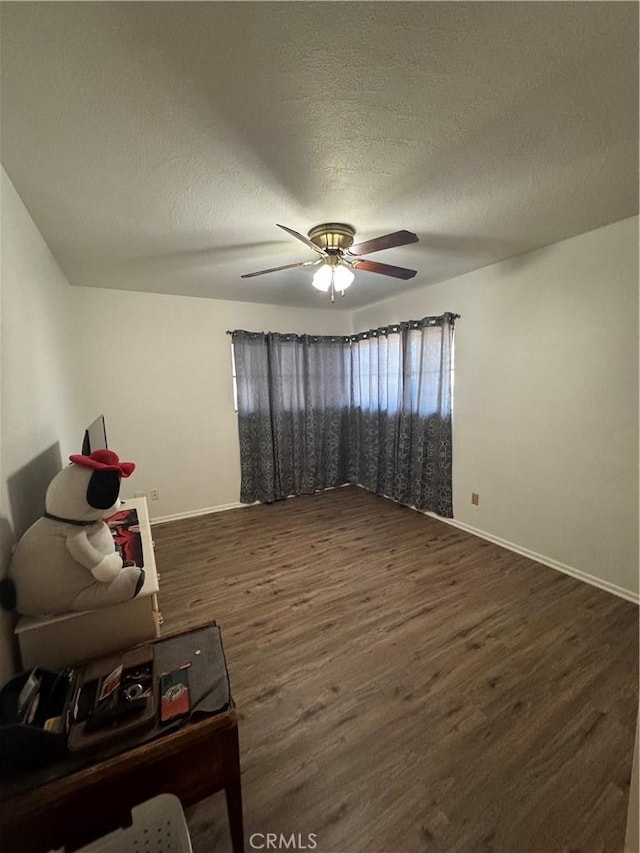 1004 Paloma St, Bakersfield, CA 93304 - living area featuring dark wood-style flooring, a ceiling fan, and a textured ceiling