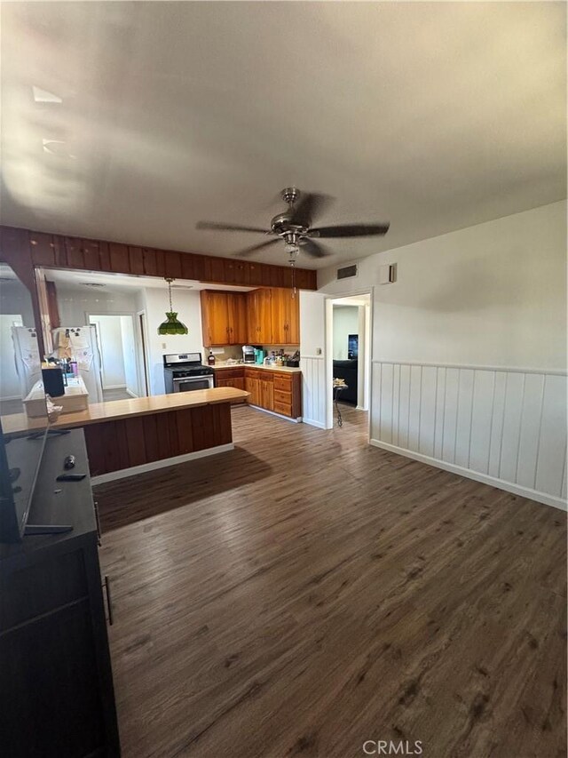 1004 Paloma St, Bakersfield, CA 93304 - kitchen with stainless steel stove, dark wood finished floors, brown cabinets, open floor plan, and a ceiling fan