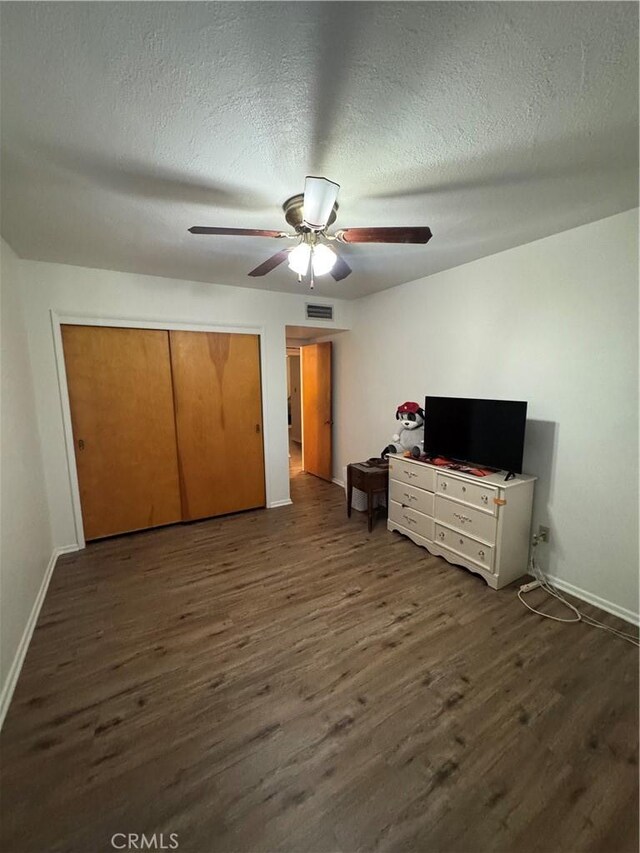 1004 Paloma St, Bakersfield, CA 93304 - bedroom featuring dark wood-style floors, a textured ceiling, ceiling fan, and a closet