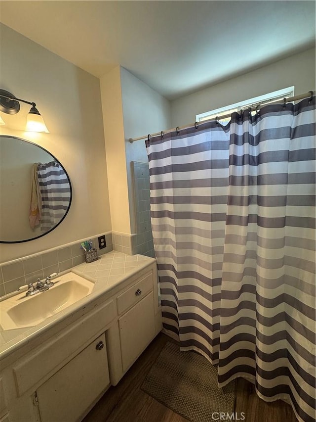 1004 Paloma St, Bakersfield, CA 93304 - full bathroom with wood finished floors, vanity, and a shower with shower curtain