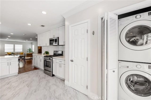 321 N Keystone St, Burbank, CA 91506 - washroom featuring stacked washer / dryer, recessed lighting, and light marble finish flooring