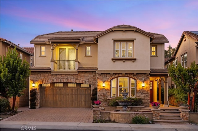 27684 Manor Hill Rd, Laguna Niguel, CA 92677 - mediterranean / spanish-style house with stone siding, stucco siding, decorative driveway, and an attached garage