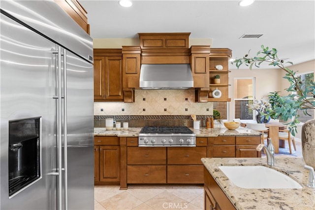 27684 Manor Hill Rd, Laguna Niguel, CA 92677 - kitchen with stainless steel appliances, brown cabinets, wall chimney range hood, decorative backsplash, and recessed lighting
