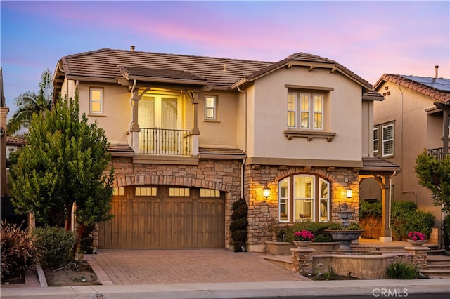 27684 Manor Hill Rd, Laguna Niguel, CA 92677 - view of front of house with an attached garage, stone siding, decorative driveway, stucco siding, and a tiled roof