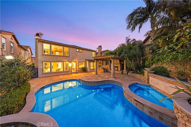 27684 Manor Hill Rd, Laguna Niguel, CA 92677 - pool at dusk featuring an in-ground hot tub, an outdoor pool, a pergola, and a patio