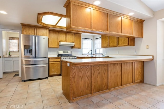 2911 Gilead Ln, Paso Robles, CA 93446 - kitchen with stainless steel appliances, under cabinet range hood, brown cabinets, light countertops, and a peninsula