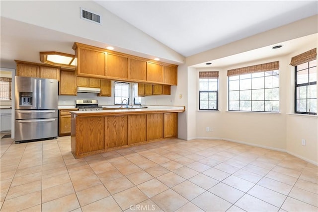 2911 Gilead Ln, Paso Robles, CA 93446 - kitchen with appliances with stainless steel finishes, brown cabinetry, a peninsula, lofted ceiling, and under cabinet range hood