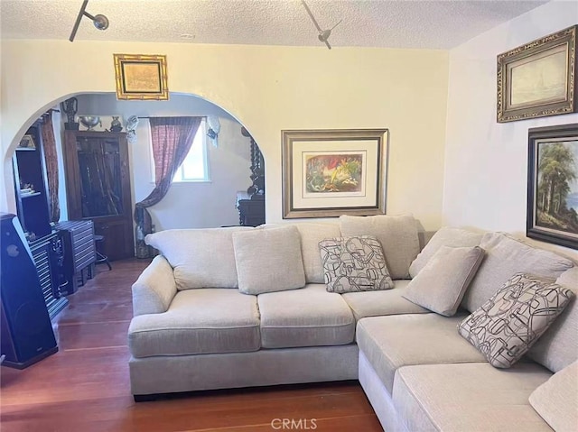 934 W 12th St, Pomona, CA 91766 - living room featuring wood finished floors, a textured ceiling, and arched walkways