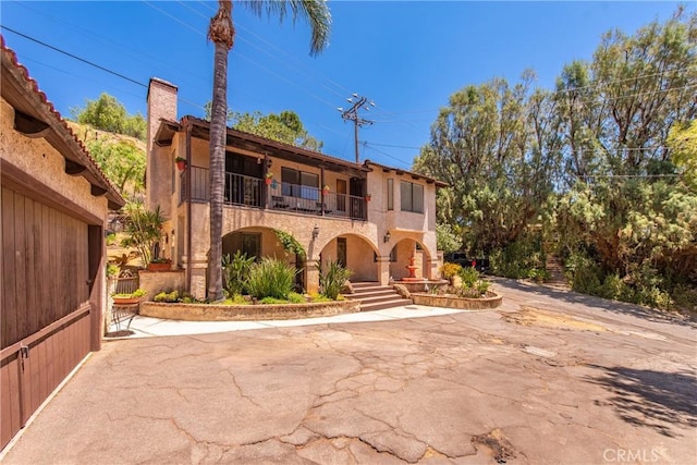 9349 Hartman Way, West Hills, CA 91304 - view of front of home with a balcony, a chimney, and stucco siding