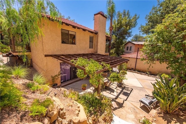 9349 Hartman Way, West Hills, CA 91304 - back of house featuring a patio area, a chimney, and stucco siding