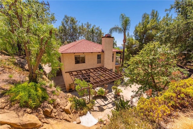 9349 Hartman Way, West Hills, CA 91304 - view of side of property with a chimney, a patio area, stucco siding, a tiled roof, and a balcony