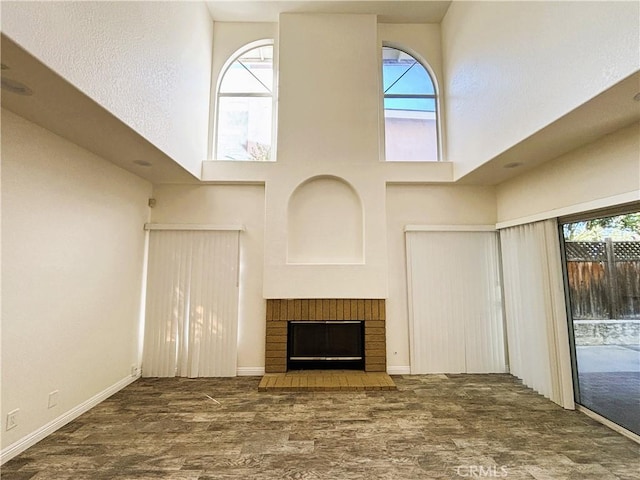493 Hillsborough Way, Corona, CA 92879 - unfurnished living room featuring a towering ceiling, wood finished floors, a fireplace, and plenty of natural light