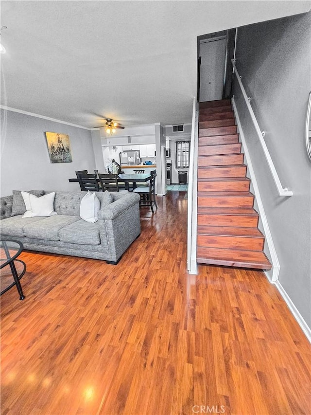 10659 Lakefront Dr, Norwalk, CA 90650 - living room featuring stairs, a ceiling fan, and wood finished floors