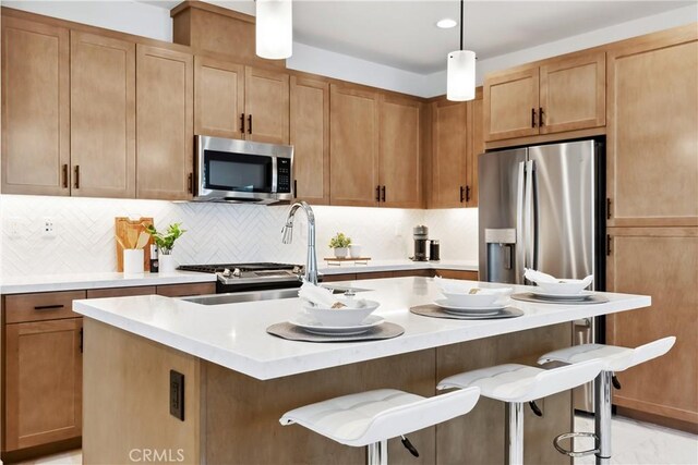2371 Horseback Rd, Rancho Mission Viejo, CA 92694 - kitchen featuring appliances with stainless steel finishes, light countertops, a kitchen breakfast bar, and a center island with sink