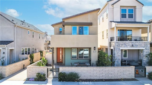2371 Horseback Rd, Rancho Mission Viejo, CA 92694 - view of front of property with a gate, a fenced front yard, stucco siding, a standing seam roof, and covered porch
