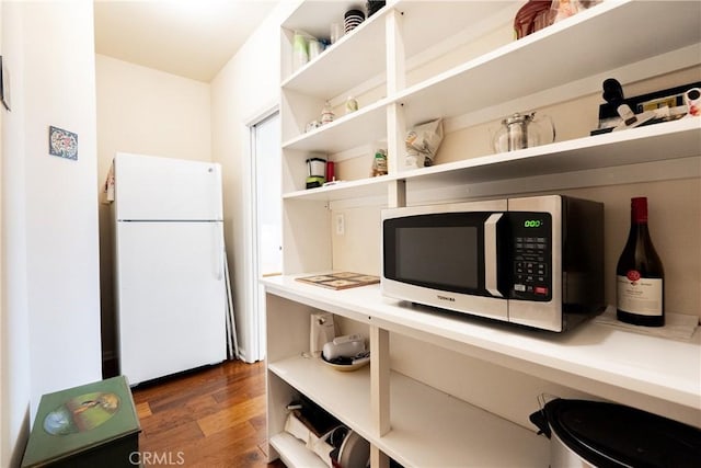 6600 San Gabriel Rd, Atascadero, CA 93422 - kitchen with freestanding refrigerator, stainless steel microwave, open shelves, wood finished floors, and light countertops