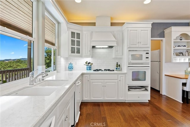 6600 San Gabriel Rd, Atascadero, CA 93422 - kitchen with white appliances, premium range hood, white cabinetry, crown molding, and dark wood-style floors