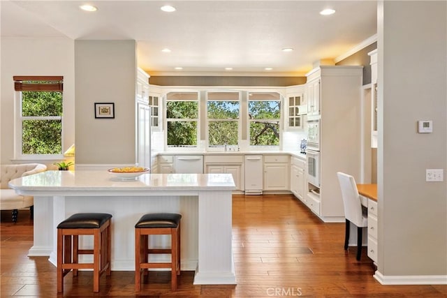 6600 San Gabriel Rd, Atascadero, CA 93422 - kitchen with a kitchen bar, glass insert cabinets, dark wood finished floors, crown molding, and white appliances