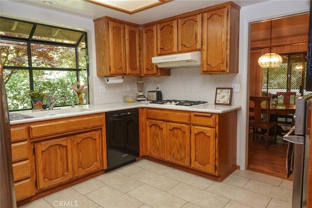 2787 Grape Way, Chico, CA 95973 - kitchen with black dishwasher, under cabinet range hood, brown cabinets, white gas stovetop, and light countertops