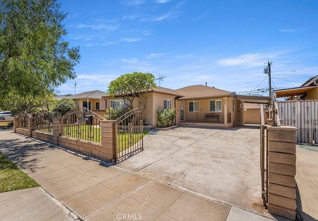 261 Twickenham Ave, Los Angeles, CA 90022 - view of front facade with stucco siding, driveway, a fenced front yard, a carport, and a gate
