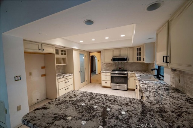 25967 Pleasant St, Hemet, CA 92544 - kitchen with appliances with stainless steel finishes, a tray ceiling, tasteful backsplash, arched walkways, and stone counters