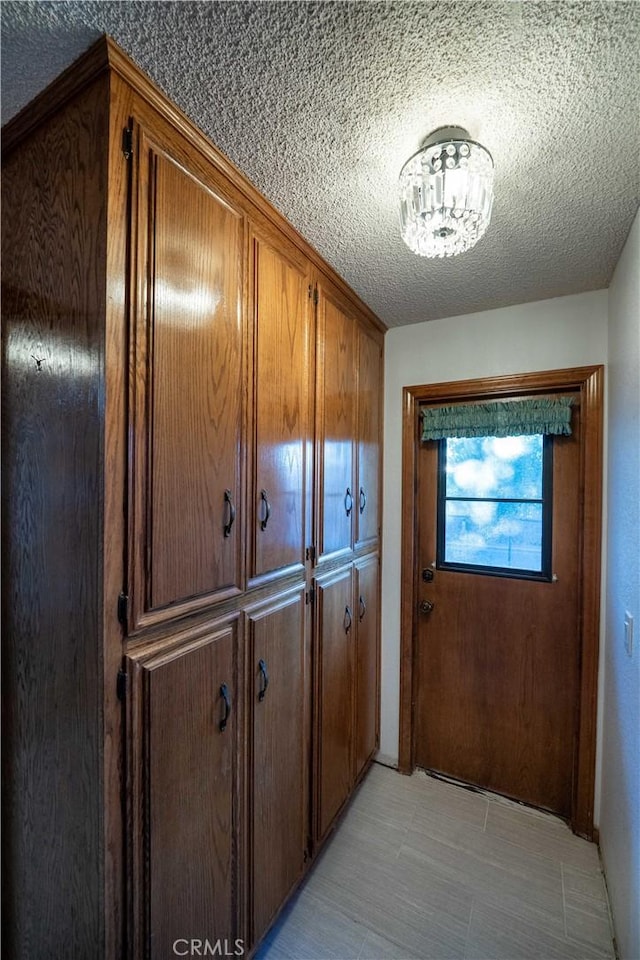 25967 Pleasant St, Hemet, CA 92544 - doorway to outside featuring a textured ceiling and a chandelier