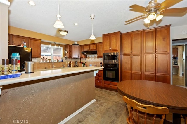 2734 Grove St, La Verne, CA 91750 - kitchen featuring black oven, stainless steel microwave, brown cabinets, decorative backsplash, and recessed lighting