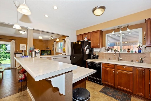 2734 Grove St, La Verne, CA 91750 - kitchen with black appliances, plenty of natural light, a kitchen bar, and light countertops