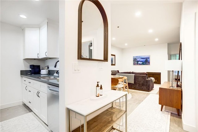 525 S Berendo St Unit 212, Los Angeles, CA 90020 - kitchen featuring stainless steel dishwasher, dark countertops, white cabinets, light wood-style flooring, and recessed lighting