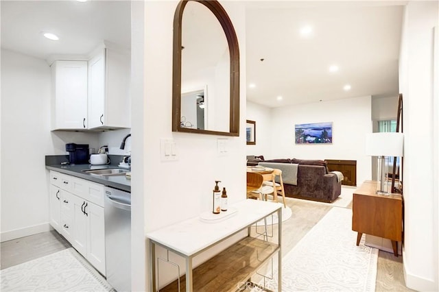525 S Berendo St Unit 212, Los Angeles, CA 90020 - kitchen with stainless steel dishwasher, dark countertops, white cabinetry, light wood-style floors, and recessed lighting