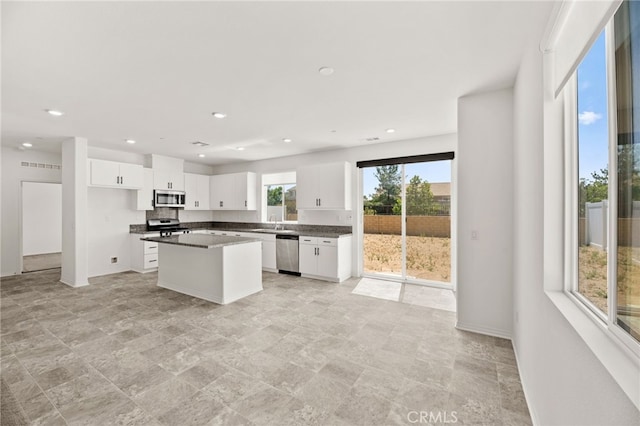 30181 Adrift Ln, Menifee, CA 92584 - kitchen with stainless steel appliances, white cabinets, dark countertops, recessed lighting, and a center island