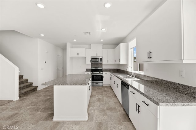 30181 Adrift Ln, Menifee, CA 92584 - kitchen with stainless steel appliances, a kitchen island, white cabinets, recessed lighting, and light stone finish flooring