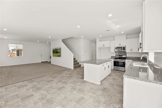 30181 Adrift Ln, Menifee, CA 92584 - kitchen featuring stainless steel appliances, recessed lighting, light stone countertops, open floor plan, and white cabinets