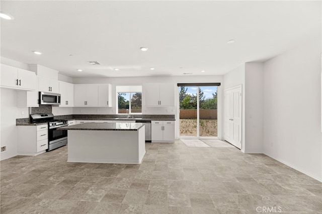 30181 Adrift Ln, Menifee, CA 92584 - kitchen featuring stainless steel appliances, dark countertops, a center island, white cabinetry, and recessed lighting