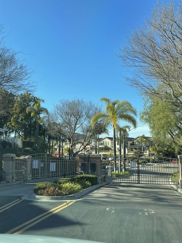 18680 Caminito Cantilena Unit 230, San Diego, CA 92128 - view of asphalt street featuring a gate, curbs, and a gated entry