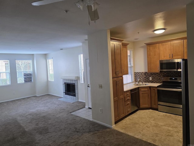 18680 Caminito Cantilena Unit 230, San Diego, CA 92128 - kitchen with appliances with stainless steel finishes, light colored carpet, a ceiling fan, open floor plan, and backsplash