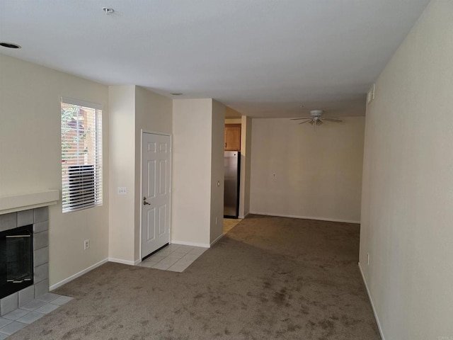 18680 Caminito Cantilena Unit 230, San Diego, CA 92128 - unfurnished living room with light carpet, a tiled fireplace, and ceiling fan