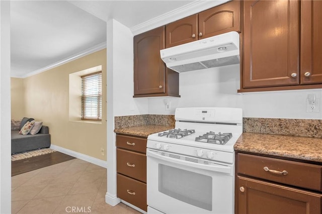 13303 Waco St Unit 62, Baldwin Park, CA 91706 - kitchen featuring white gas range, under cabinet range hood, ornamental molding, light tile patterned floors, and light stone counters