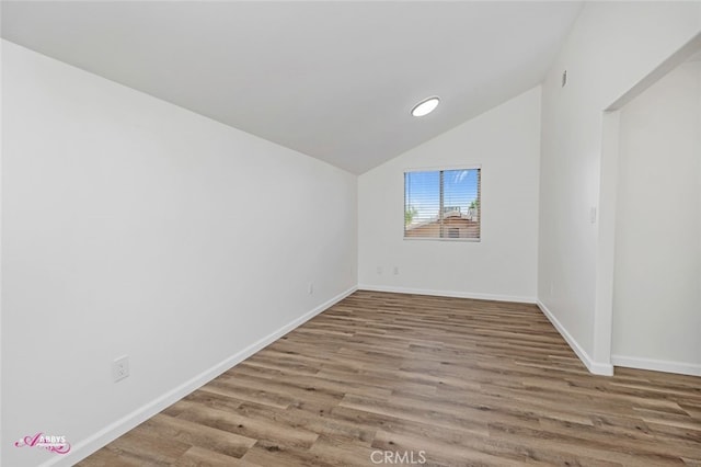 bonus room with wood finished floors and vaulted ceiling