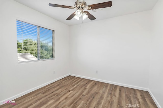 spare room with wood finished floors and ceiling fan