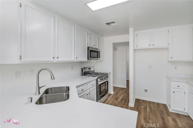 kitchen with stainless steel appliances, dark wood-type flooring, white cabinets, and light countertops