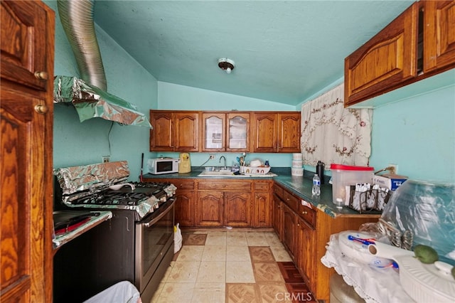 526 Nottingham Ave, Santa Ana, CA 92703 - kitchen featuring gas stove, white microwave, brown cabinetry, lofted ceiling, and dark countertops