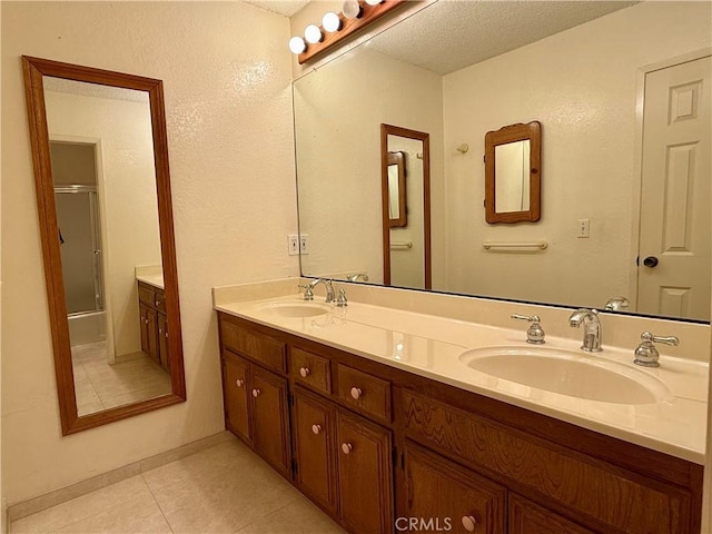 2402 Aviation Blvd Unit C, Redondo Beach, CA 90278 - bathroom featuring double vanity, tile patterned floors, an enclosed shower, and a textured ceiling