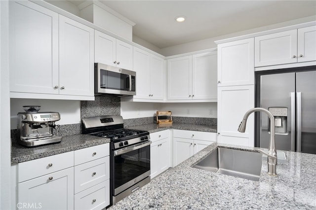 16502 Casa Grande Ave Unit 102, Fontana, CA 92336 - kitchen with appliances with stainless steel finishes, white cabinetry, recessed lighting, and dark stone countertops
