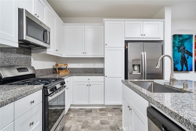 16502 Casa Grande Ave Unit 102, Fontana, CA 92336 - kitchen with stainless steel appliances, white cabinetry, light stone counters, and stone finish floors