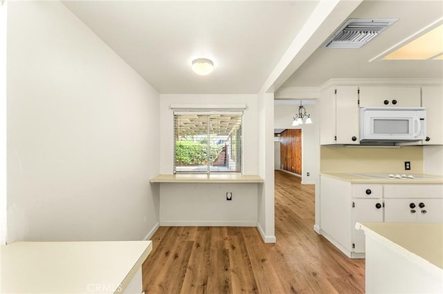 1204 San Jacinto, Redlands, CA 92373 - kitchen featuring white microwave, white cabinetry, light wood-style floors, light countertops, and cooktop